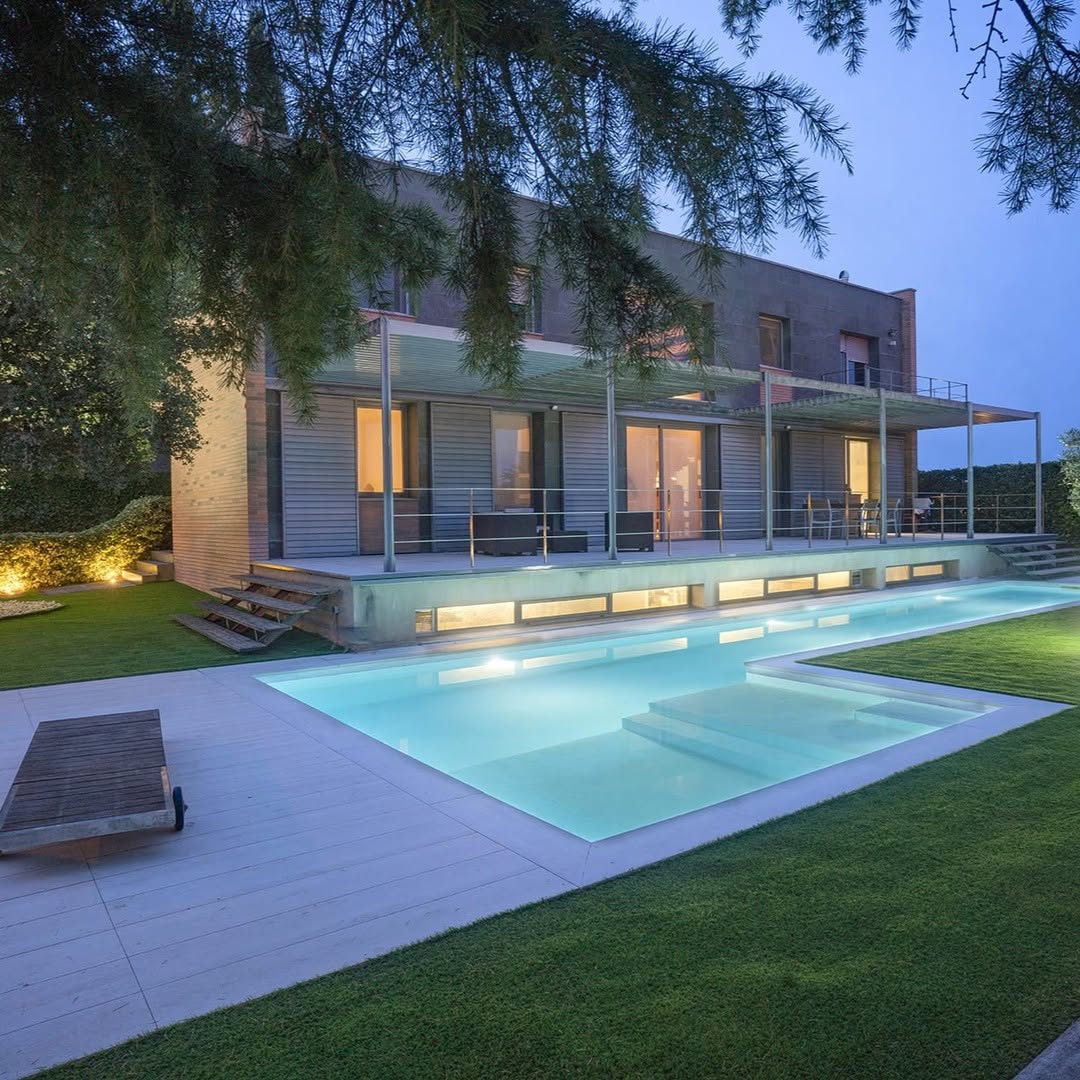 Piscina iluminada integrada con la vivienda y la terraza en Lleida